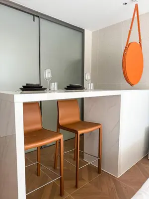 a kitchen with two chairs and a bar with mirrors at Sunshine Layan Beach Resort studio #84191 in Layan Beach