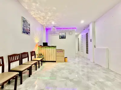 a waiting room with chairs and a counter with purple lighting at Jasmine Residence in Patong Beach