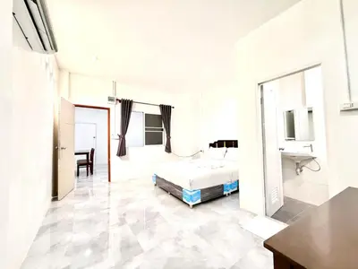 a white bedroom with a bed and a bathroom at Jasmine Residence in Patong Beach
