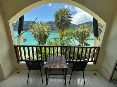 a table and chairs on a balcony with a view of the water at Nanworld travel sea view room in Phi Phi Don