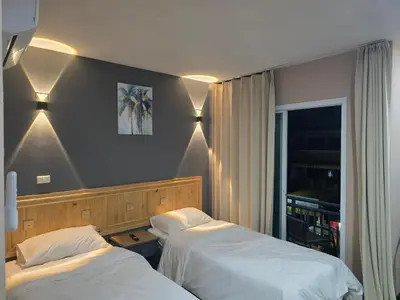 a bedroom with two beds and lights on the wall at Yolo\u6d77\u9493\u4ff1\u4e50\u90e8\u516c\u5bd3 in Ban Bang Chak