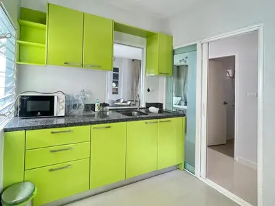 a kitchen with lime green cabinets and a microwave at Cozy Serene Home Quiet Garden for a Peaceful Stay in Phuket Town