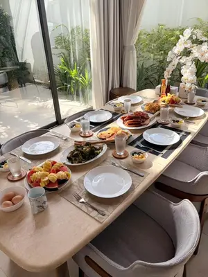 a wooden table with plates of food on it at The White Courtyard Sanctuary 4BR Pool Viila in Koh Lone