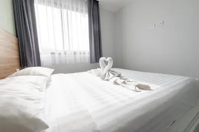 a white bed with a ribbon on it with a window at Charming 1-Bed Apt (T3- 629) in Phuket Town