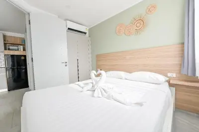 a bedroom with a white bed with a bow on it at Charming 1-Bed Apt (T3- 629) in Phuket Town