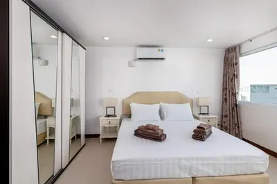 a bedroom with a bed with two brown bags on it at Karon Sea View 2 Bedrooms Apartment in Karon Beach