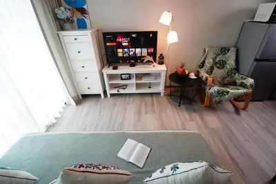 a living room with a tv and a couch at Title - Comfortable 1BR Tropical Retreat in Nai Yang Beach