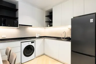 a kitchen with white cabinets and a washer and dryer at Bangtao The Title Legendary by Phuket Sabay Rent G201 in Bang Tao Beach