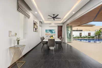 a dining room with a table and chairs and a pool at Villa Hemi 2BR Modern Thai Style with Private Pool in Rawai Beach