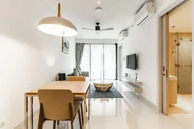 a dining room and living room with a table and chairs at Cassia Residence by Villacarte in Laguna Phuket