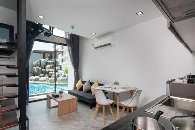 a living room with a table and a couch at Duplex 1 BR Apt UTL B112 - Direct Pool Access in Rawai Beach