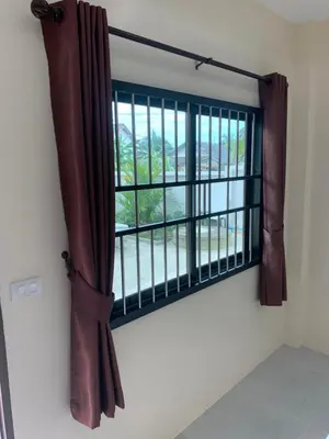 a window with brown curtains in a room at ZAMZAM House in Thalang