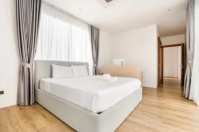 a white bedroom with a large bed with white sheets at 3BR Pool Villa JAAI in Ban Saiyuan (1)