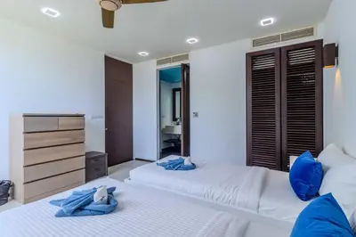 a bedroom with two beds with blue towels on them at C254 Condo 2BR Pool View Short Walk to Beach in Thalang