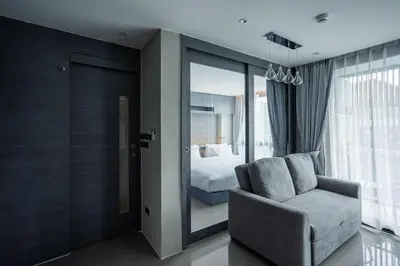 a living room with a chair and a bedroom at C252 Great Facility Condo Near Beach & Rooftop Pool in Kamala Beach