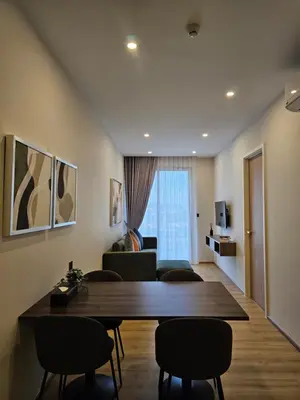 a living room with a wooden table and chairs at Wora Phuket in Ban Sam Kong