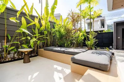a patio with a bench and some plants at Aileen Naithon Hills - Tropical Haven Retreat in Nai Thon Beach