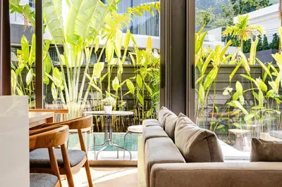 a living room with a couch and tables and plants at Aileen Naithon Hills - Tropical Haven Retreat in Nai Thon Beach