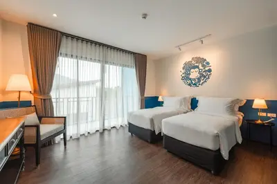 a hotel room with two beds and a couch at Blu Monkey Boutique Naiharn - Serviced Apartments 1 Bedroom in Rawai Beach