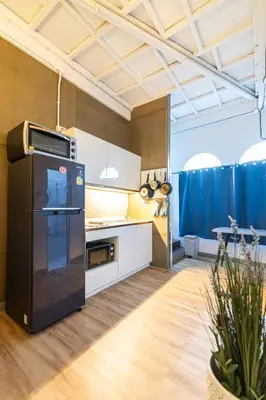 a kitchen with a black refrigerator and white cabinets at Queen On Street 2009 in Ban Lo Long