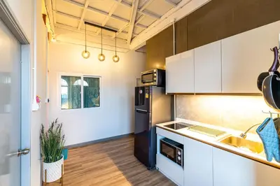 a kitchen with white cabinets and a black refrigerator at Queen On Street 2009 in Ban Lo Long