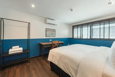 a bedroom with a white bed and a blue wall at Blu Monkey Boutique Naiharn - Serviced Apartments 2 Bedrooms in Rawai Beach