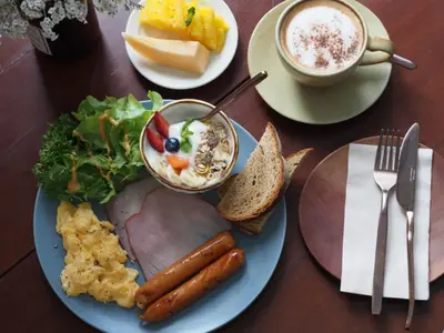 a table with a plate of food and a cup of coffee at Blu Monkey Boutique Naiharn - Serviced Apartments 2 Bedrooms in Rawai Beach