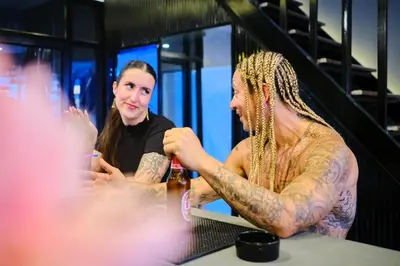 a man with tattoos sitting at a table with a woman at Friendz Hostel in Phi Phi Don