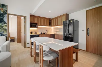 a kitchen with a table and a black refrigerator at Laguna Beach Residences Seashore by Banyan Living in Thalang