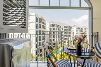 a balcony with a table and chairs and a view of a building at Tropical studio Luxury Amenities and Pool in Bang Tao Beach