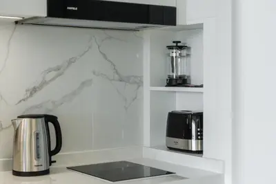 a kitchen with a counter top with a coffee maker at Elegant Beachside Retreat Modern Stay Pool Bar in Layan Beach