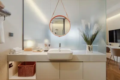 a bathroom with a sink and a mirror at Elegant Beachside Retreat Modern Stay Pool Bar in Layan Beach