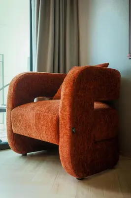 an orange couch sitting in a living room at Bangtao The Title Legendary by Phuket Sabay Rent G402 in Bang Tao Beach