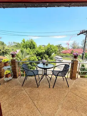 a patio with two chairs and a table on a balcony at Sachi Home Bangtao -Private House Near Beach in Ban Thalat Choeng Thale