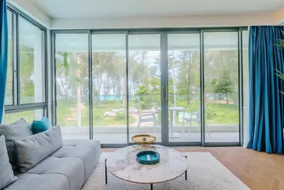 a living room with a couch and a table at Two Bedroom Sea View by Triple 8 Asia in Layan Beach