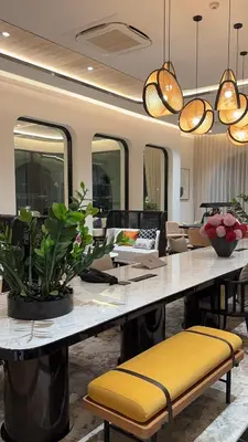a dining room with a large table with yellow seats and lights at Title Legendary in Phuket