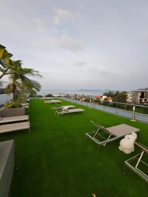 a row of lounge chairs on the roof of a building at Babylon Sky Garden 2 in Rawai Beach