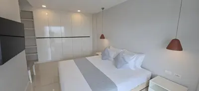 a bedroom with a white bed with two pillows at Babylon Sky Garden 2 in Rawai Beach