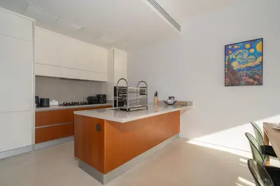 a kitchen with white walls and a wooden counter top at Thai-Balinese Pool Villa Anchan Indigo16 in Ban Phru Champa