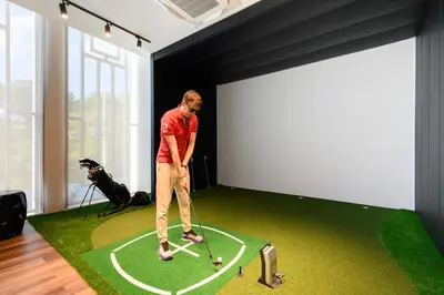 a man playing golf in a room with a golf ball at Bangtao The Title Legendary by Phuket Sabay Rent A212 in Bang Tao Beach