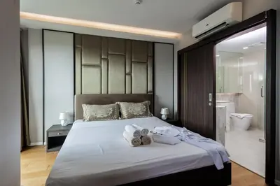 a bedroom with a large bed with towels on it at Mida Grande Ocean View in Surin Beach