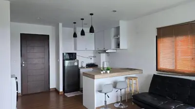 a kitchen and living room with a couch and a counter at BP Sweet Home Bang Tao - 607 in Ban Thalat Choeng Thale