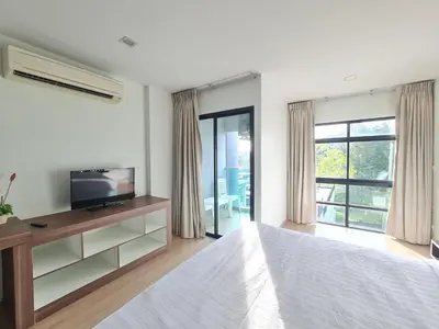 a bedroom with a bed and a tv and window at BP Sweet Home Bang Tao - Studio in Ban Thalat Choeng Thale