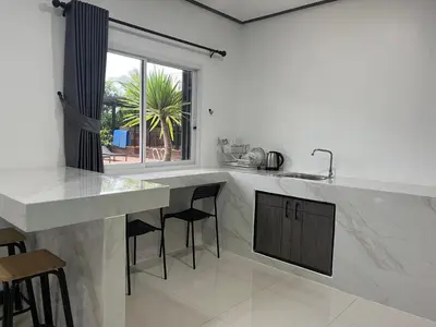 a white kitchen with a counter and a window at 365 Place Maikhao in Ban Mai Salae