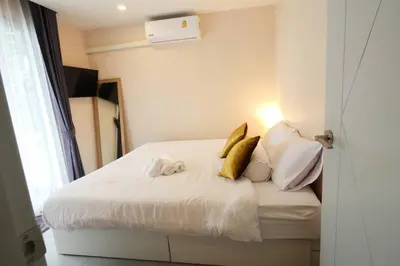 a bedroom with a bed with white sheets and pillows at Tower2 Condominium in Ban Klang