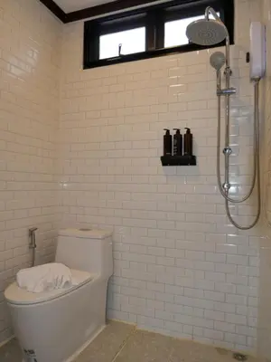 a white bathroom with a shower and a toilet at Baan Ati Villas in Ban Han Pa To