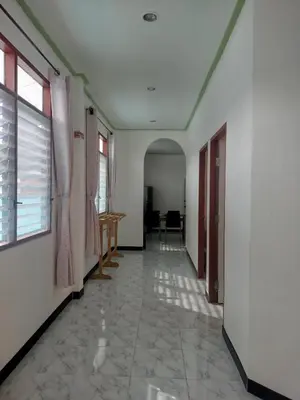 an empty hallway with a room with a table and windows at Soi Saliga in Rawai Beach