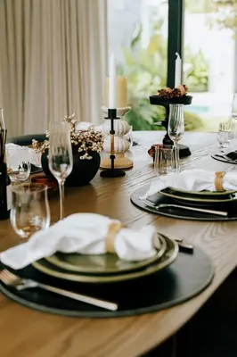 a wooden table with black plates and candles on it at Botanica Foresta B09 in Ban Phru Champa