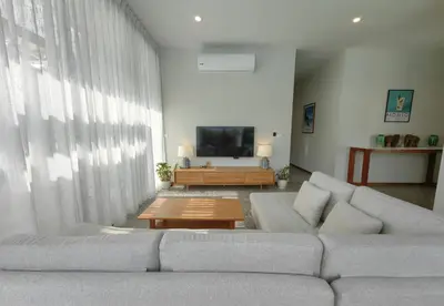 a living room with a couch and a table at Bangtao Luxury Pool Villa - PrymaSelva in Laguna Phuket