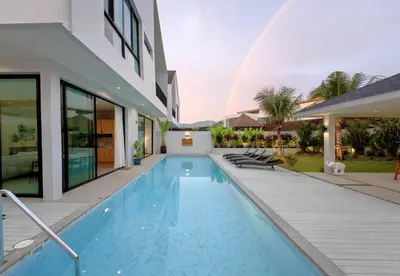 a pool in the backyard of a house with a rainbow at Bangtao Luxury Pool Villa - PrymaSelva in Laguna Phuket